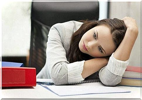 A woman with depression is sitting at her desk.