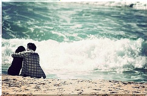 man-sitting-with-his-dog-on-the-beach