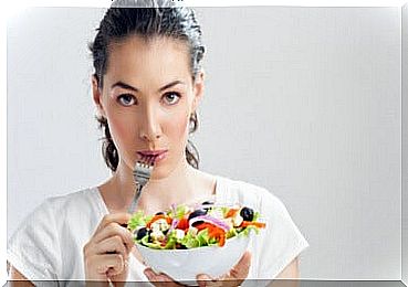 Woman eats healthy salad to prevent epigastralgia