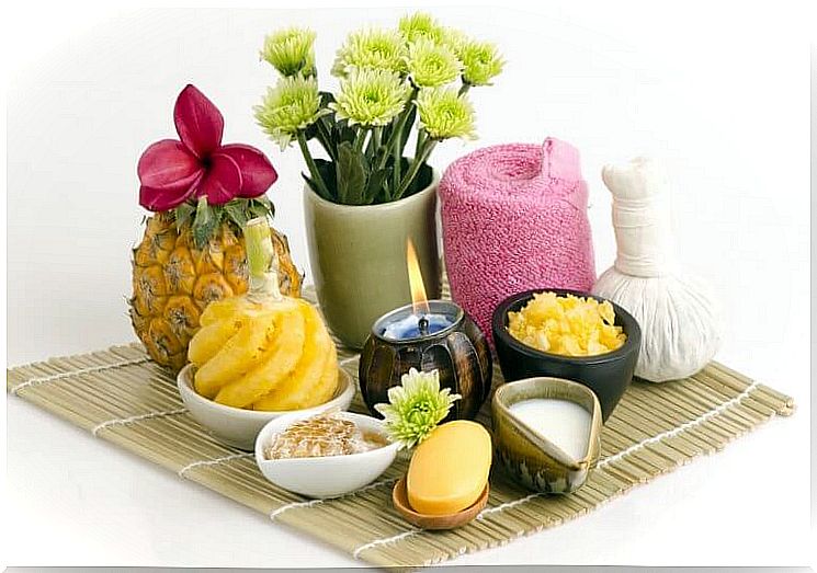 Pineapples, candles and flowers, among other things, are displayed on a table.