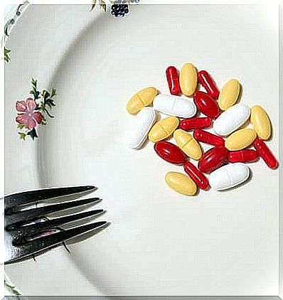 Some colorful tablets are on a plate, next to a fork.